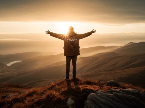 Hombre en una montaña despalda con el logo de Cloost