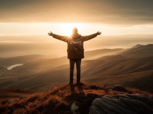 Hombre en una montaña despalda con el logo de Cloost